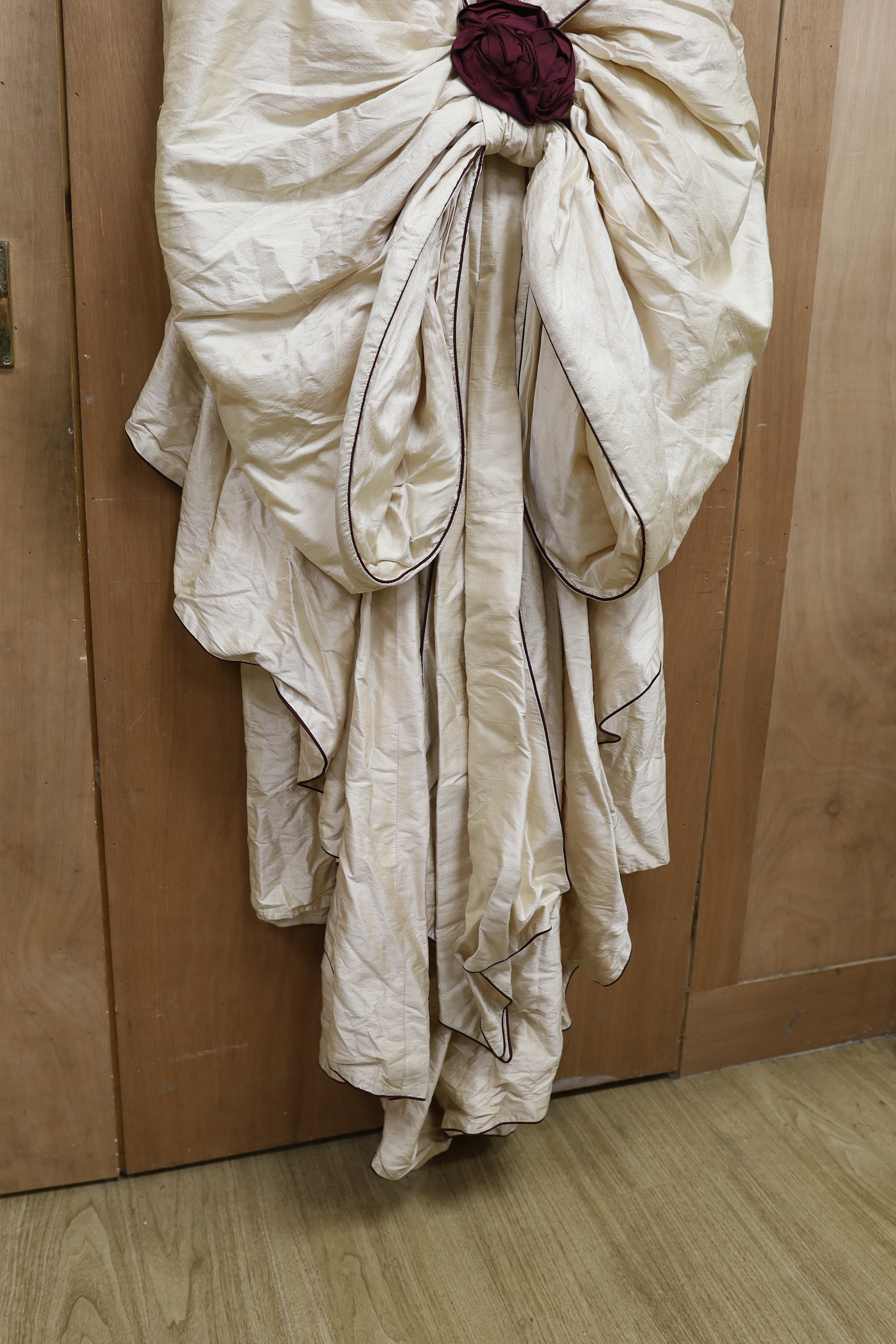 A late 20th century cream silk and burgundy trimmed gown, with bustle, possibly operatic or theatrical